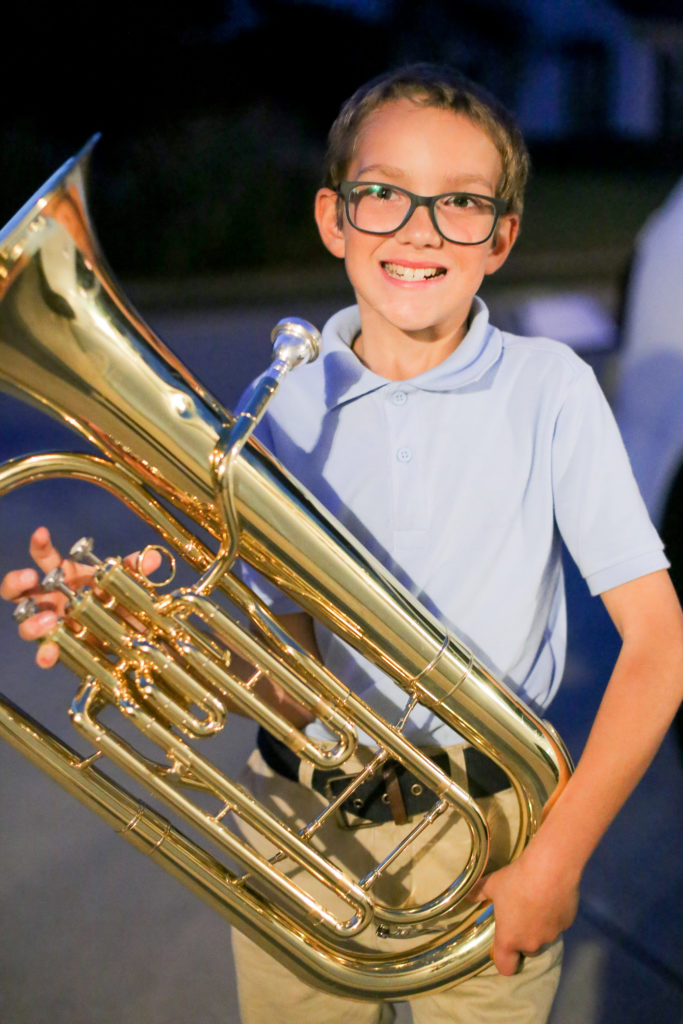 Fourth-grader Miguel Billings, 10, of Collinsville flashes a smile for a portrait with his baritone Wednesday, Nov. 2, 2016 outside of his Collinsville home. Billings has been playing the baritone for hours on end to raise money in order to build a home for a Haitian family. (Photograph by Brian Munoz / The Collinsville Chronicle)